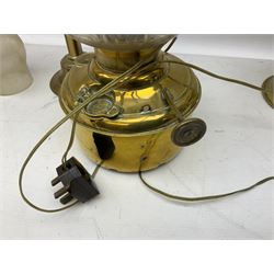 Three brass oil lamps, the shortest example converted to electricity, max H54cm