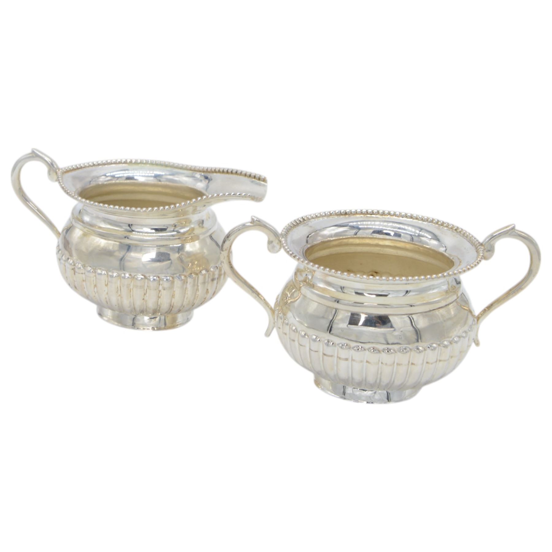 Late 20th century Indian Colonial silver six piece tea and coffee service, comprising coffee pot, hot water pot, teapot, milk jug, open sucrier and tray, all of oval part fluted form, the tea and coffee pot with ebonised wooden handles and finials, stamped SIL and with maker's mark for Cooke & Kelvey New Dehli, within two boxes and with original receipt for 1999