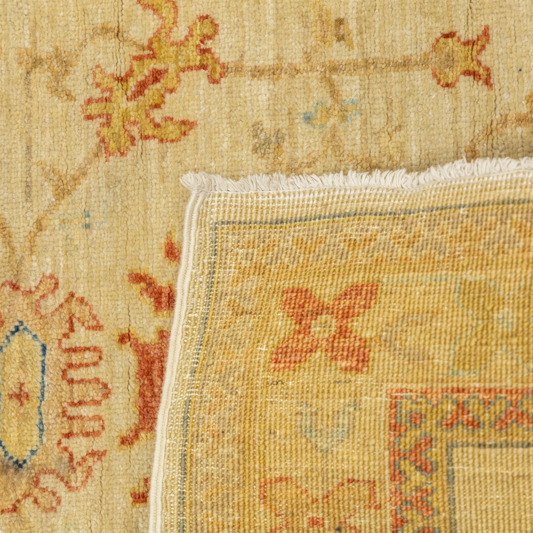 Cream ground prayer rug, with red and blue stylised motifs within a broad floral border, the field with central mihrab-style design in soft red, blue and beige tones