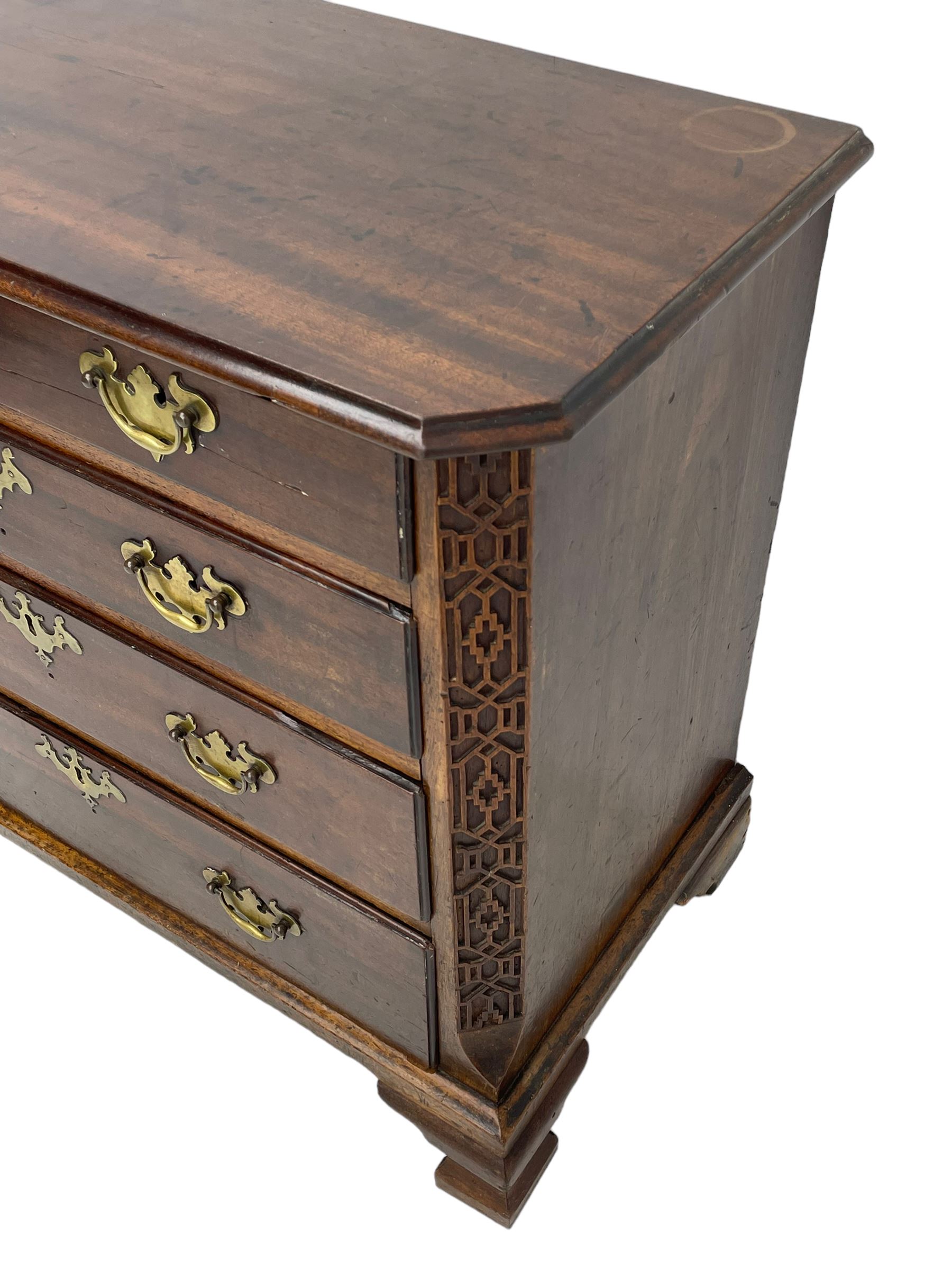 George III Chippendale design mahogany chest, moulded rectangular top with canted corners, wide canted uprights with blind fretwork decoration, two short and three long with moulded fronts, shaped brass handle plates, on ogee bracket feet 