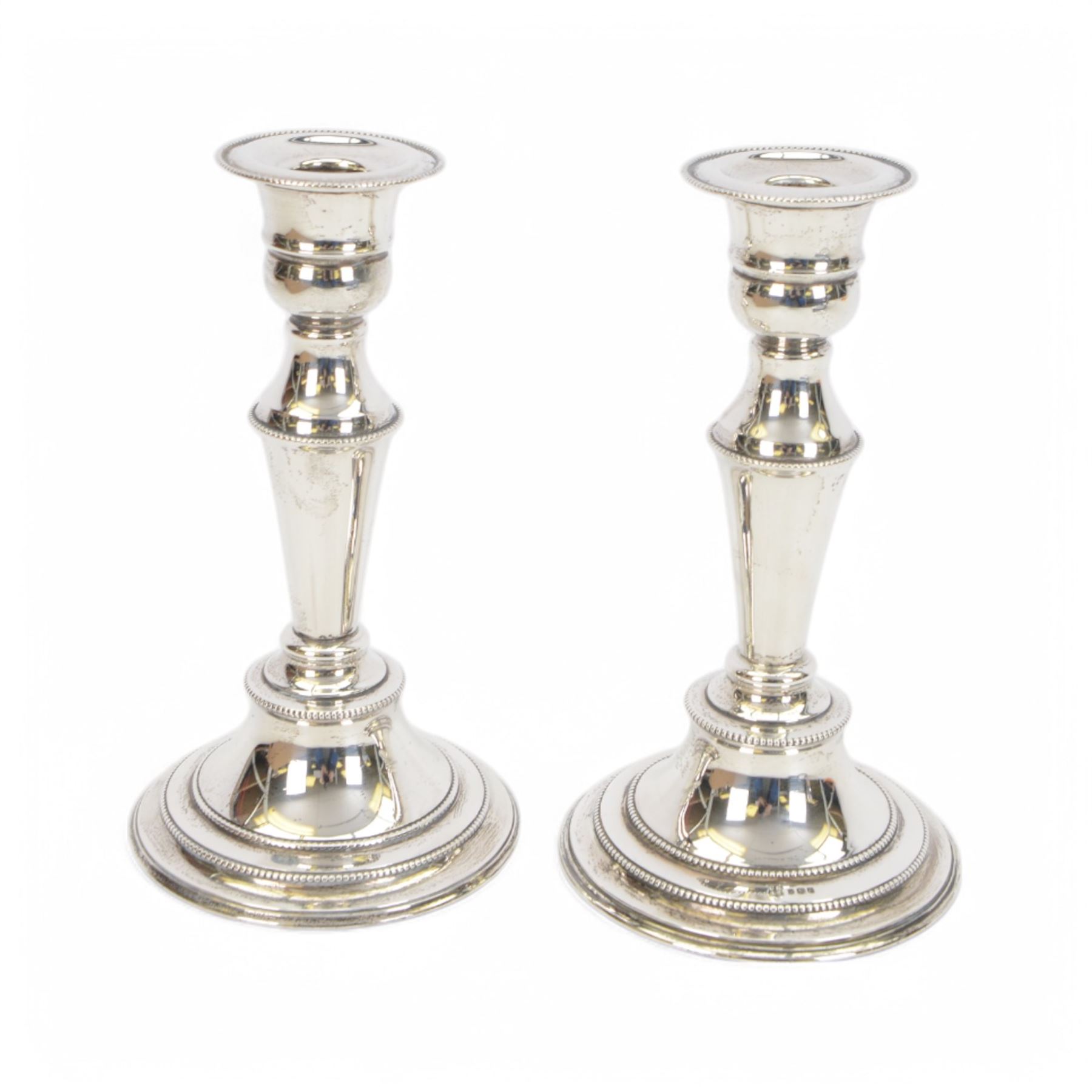 Pair of late 20th century silver mounted candlesticks, of tapering form with beaded rims, hallmarked Cooper Brothers & Sons Ltd, Sheffield 1972, H20cm