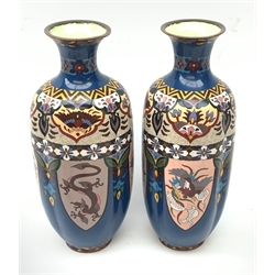 A pair of 20th century Japanese cloisonne vases, of fluted baluster form, decorated with panels contained phoenix and dragons, beneath stylised foliate bands, upon a blue ground, H37cm. 