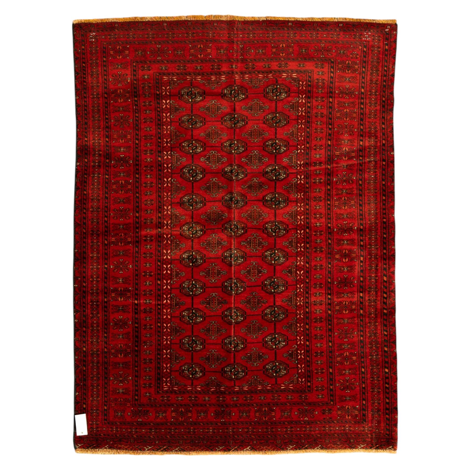 Turkman hand-knotted carpet, deep red ground, with an all-over field of repeating gul motifs arranged in rows, enclosed by multiple red geometric borders with stylised flowerheads and hooked motifs, flanked by narrow patterned guard stripes, with wool fringes
