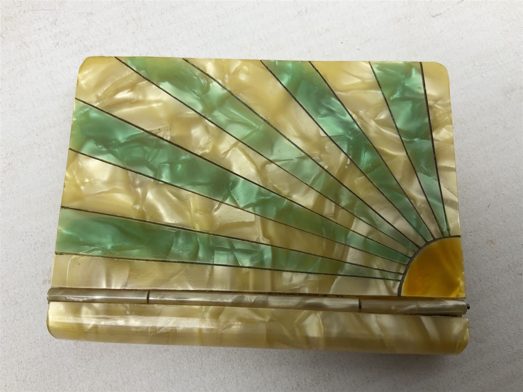Mother of pearl and abalone inlaid card case, with central diamond shaped panel engraved with foliate decoration, together with a simulated mother of pearl card case of book form with green sun rays to cover, and simulated wood effect cigarette case with hinged lid with diamante style banding, largest L10cm