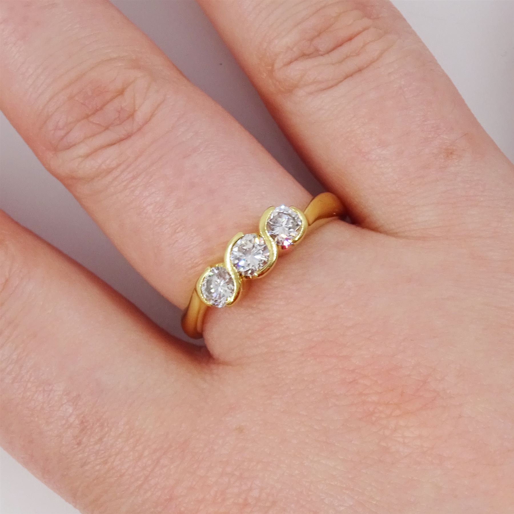 18ct gold diamond three stone ring, half bezel set with round brilliant cut diamonds, London 2002, total diamond weight approx 0.75 carat