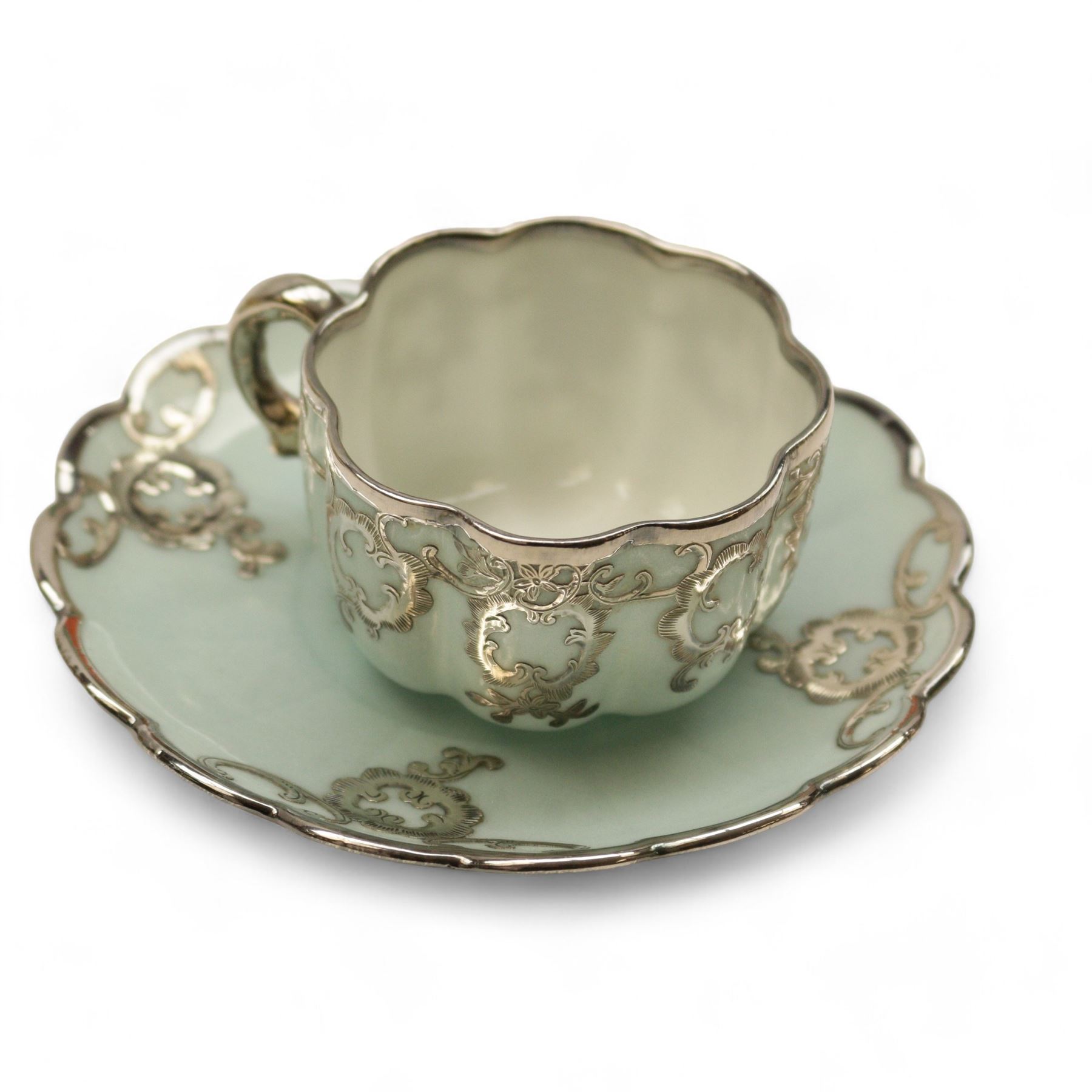 Three Pirkenhammer cups and saucers, two decorated with gilt birds in foliage on an ivory ground, the other with butterflies and foliate sprigs together with three  continental cups and saucers decorated with silver overlay 