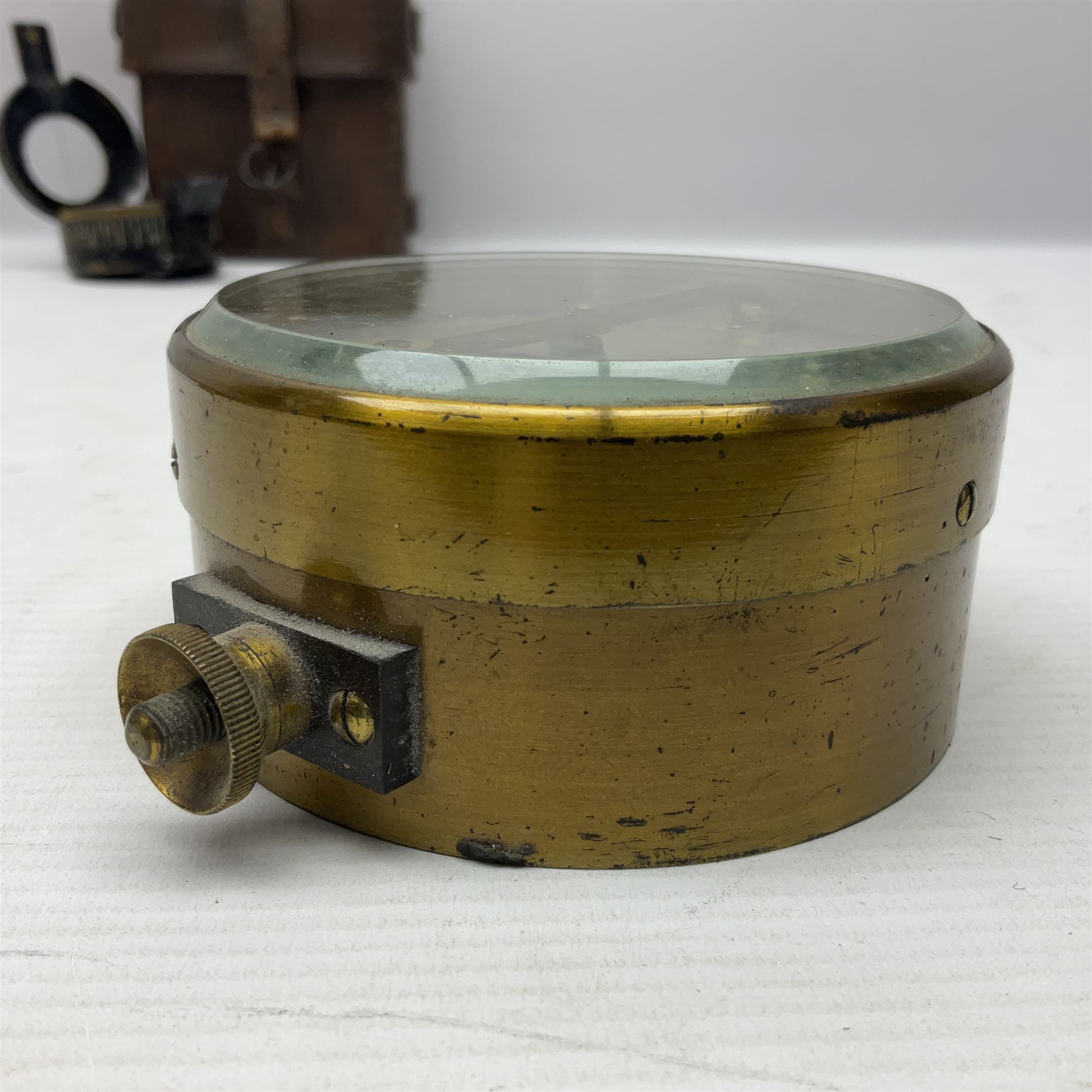 WWII British marching compass, the black lacquered brass case inscribed T.G.Co.Ltd. No.B100228 (broad arrow) 1941 Mk.III; and a ship's brass cased clinometer, the silvered dial marked R(arrow)L, D9cm; in leather carrying case (2)