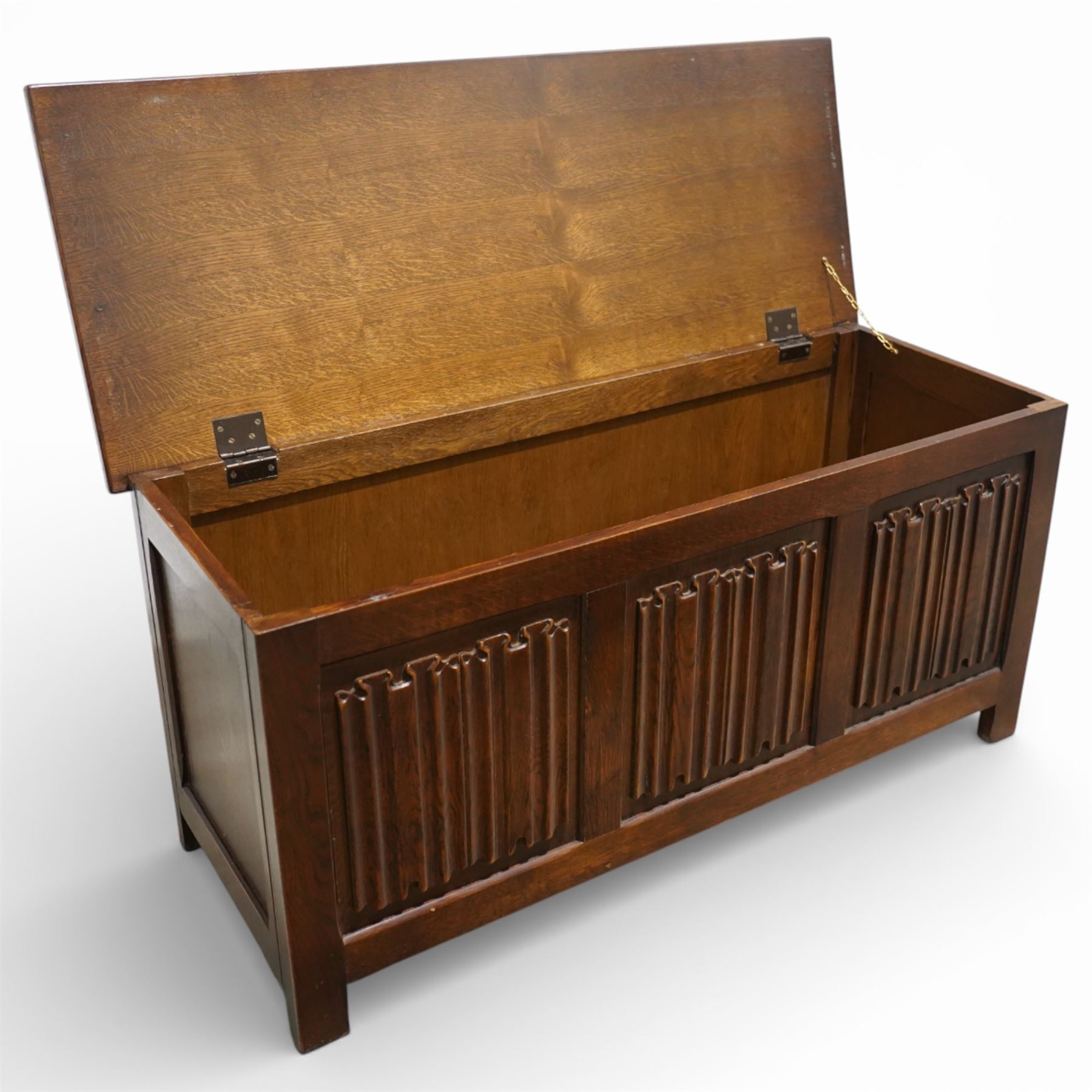 Late 20th century oak linenfold blanket box, with hinged rectangular top opening to a plain interior, the front carved with three linenfold panels, plain panelled sides, raised on stile supports