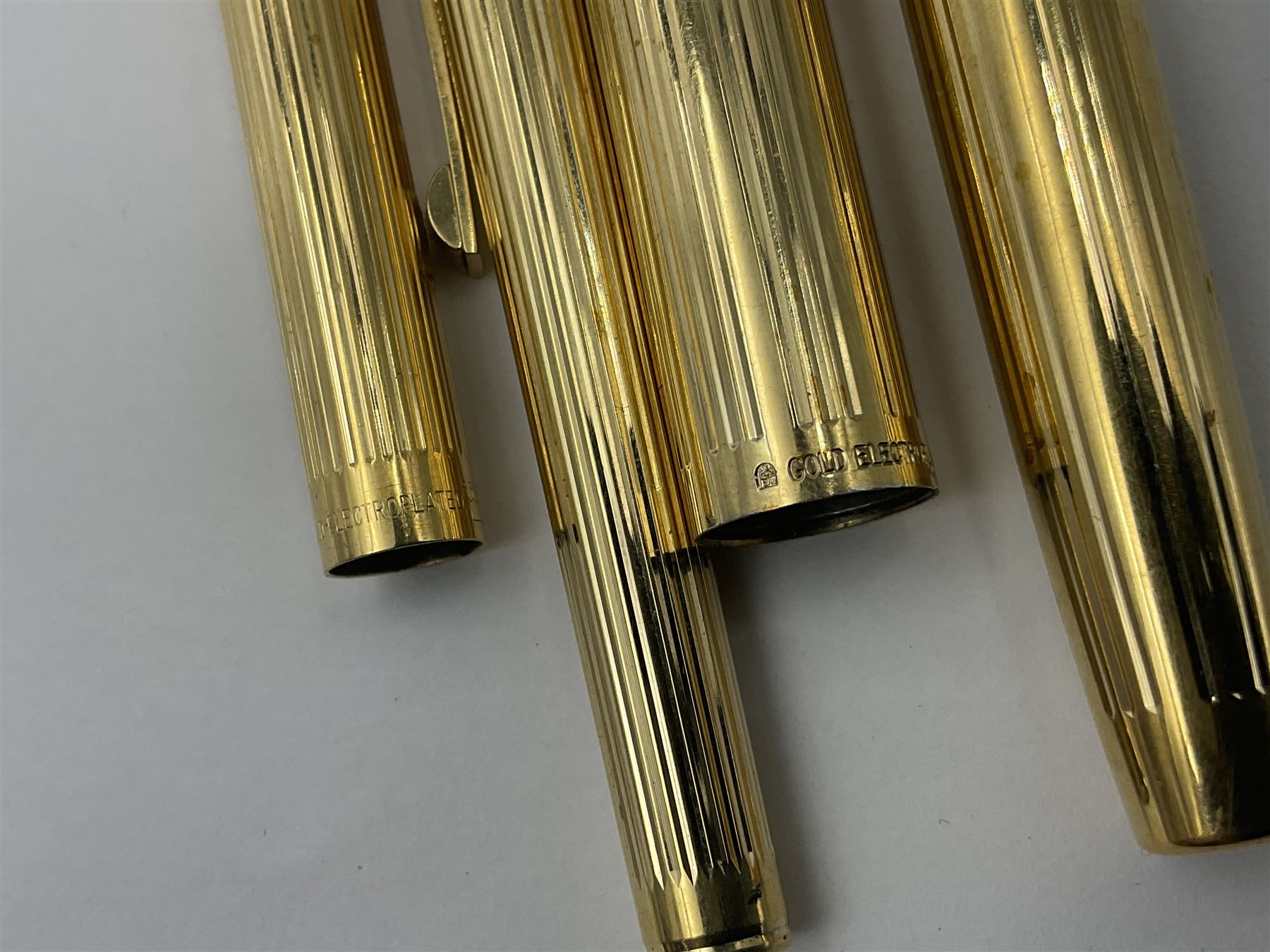 Sheaffer Triumph Imperial fountain pen, the gold plated barrel with fluted stripe design and gold nib stamped 14K 585, together with a Sheaffer Targa slimline fountain pen with gold plated barrel similarly decorated with gold nib stamped 14K 585, ballpoint pen and propelling pencil, each with a fluted gold plated barrel, largest L13.5cm (4)