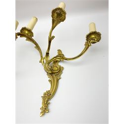 Set of three 20th century gilt metal wall sconces, each with three foliate scrolling branches rising from conforming backplates, H33cm W29cm