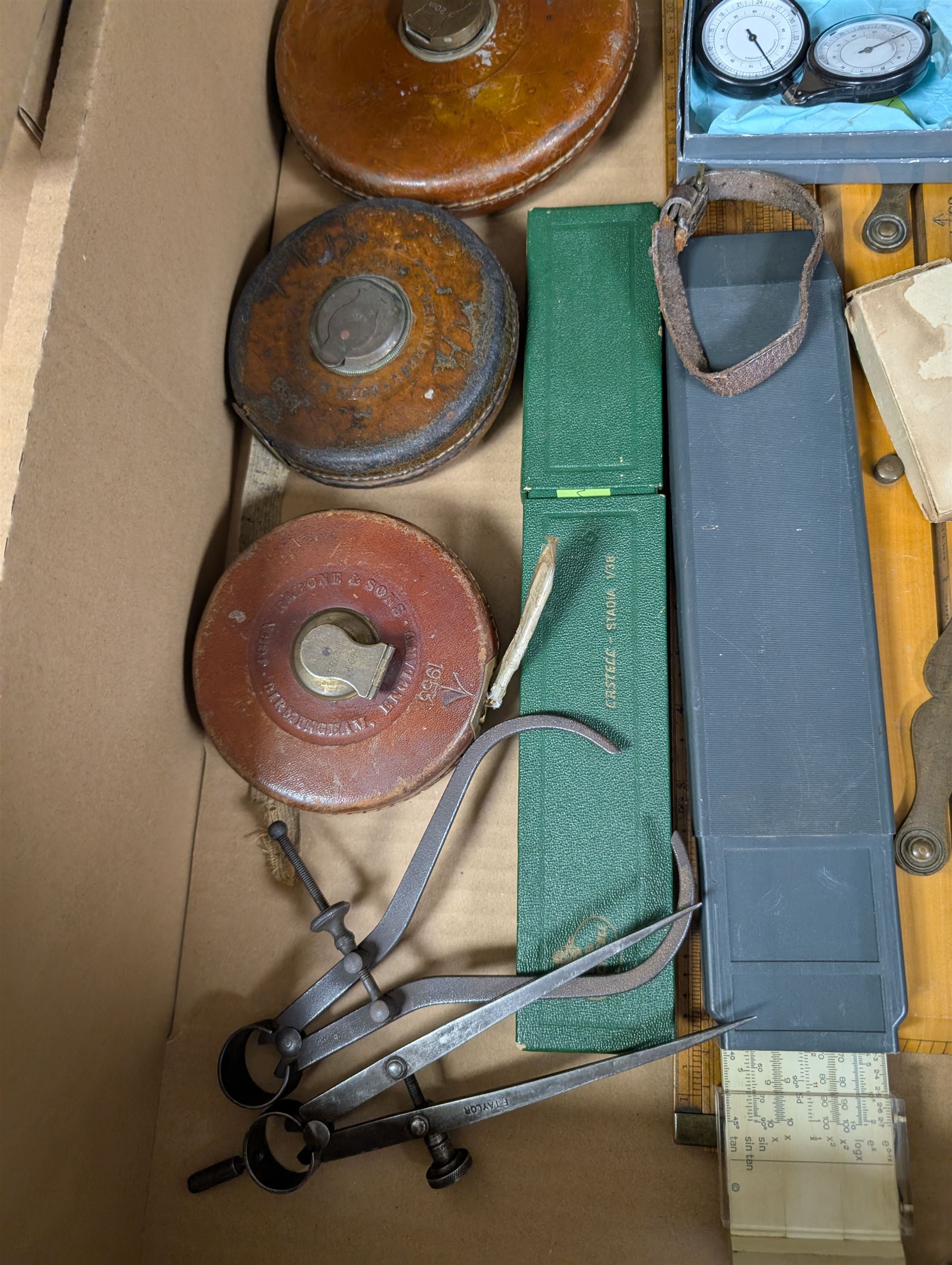 Three Rabone tape measures in leather cases, one with broad arrow, three map wheels, pair of Moore & Wright calipers, W Harling alidade in Whippy leather case with broad arrow and a collection of slide rules