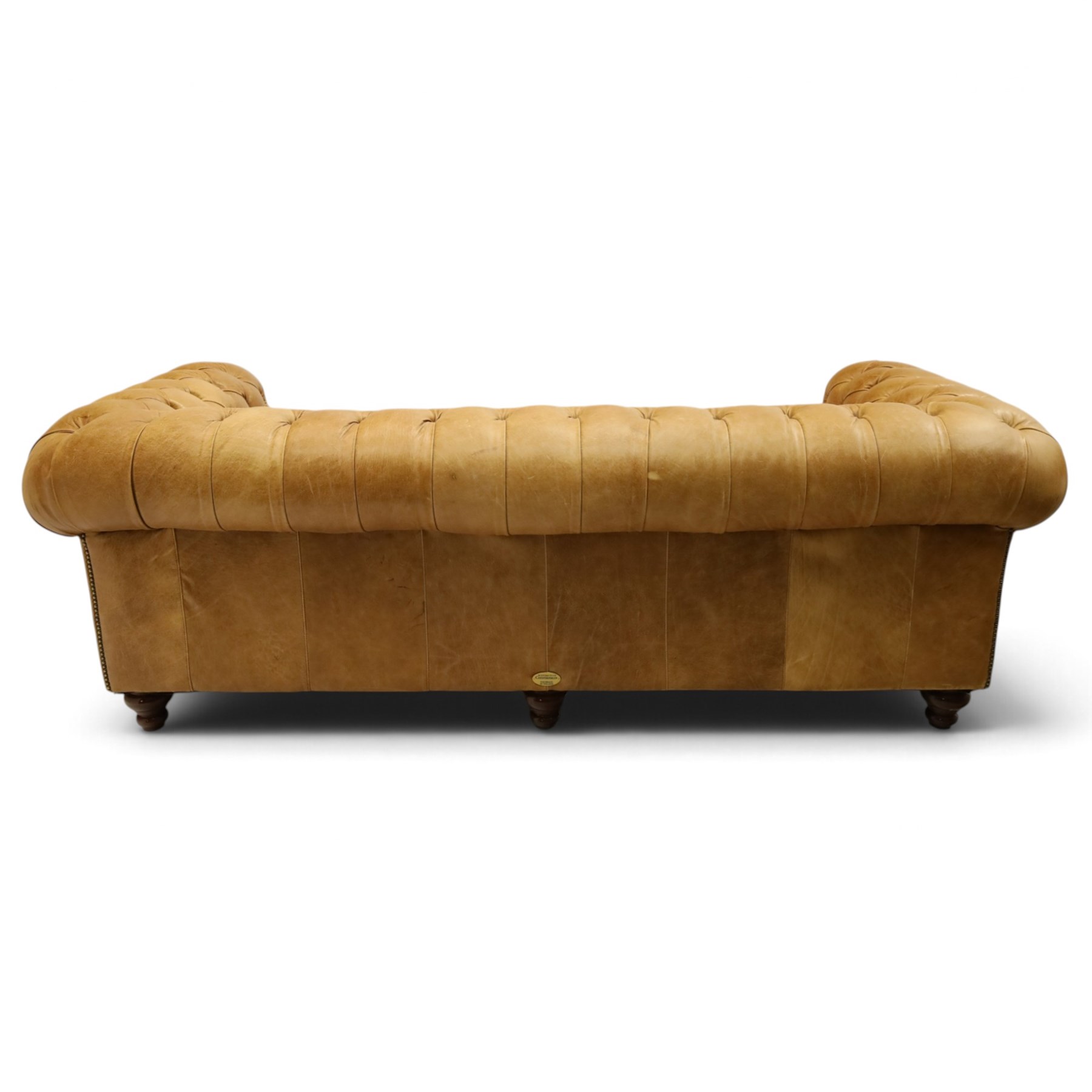 Distinctive Chesterfields - traditional shape four seater Chesterfield sofa, the rolled back and arms upholstered in deep-buttoned tan leather with matching loose seat cushions, raised on six turned supprorts
