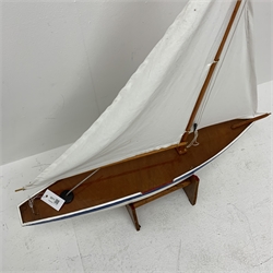 Pond yacht with white painted planked wooden hull, weighted metal keel and two sails L92cm H106cm, on wooden stand