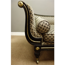  Regency ebonised chaise longue, scrolled and reeded frame, brass beading and circular mounts, turned and lobed feet with brass castors, sprung seat with seat cushion and bolster cushion upholstered in Art Deco style fabric, L223cm, H84cm, D72cm  