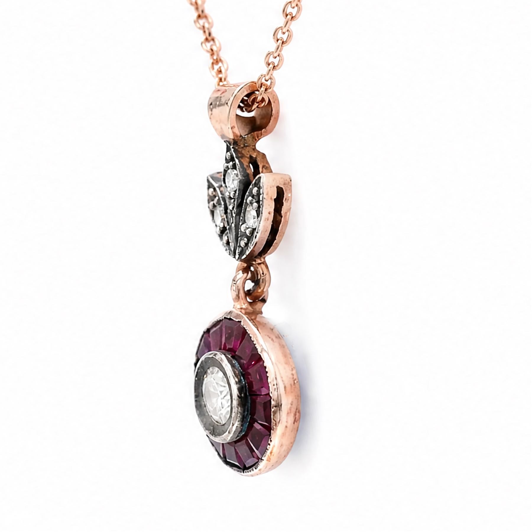 Gold and silver ruby and diamond pendant, single round brilliant cut diamond, surrounded by calibre cut rubies and round brilliant cut diamonds, suspending from a fancy pendant set with further diamonds, on a rose gold plated silver chain necklace, total diamond weight approx 0.30 carat, total ruby weight approx 0.30 carat