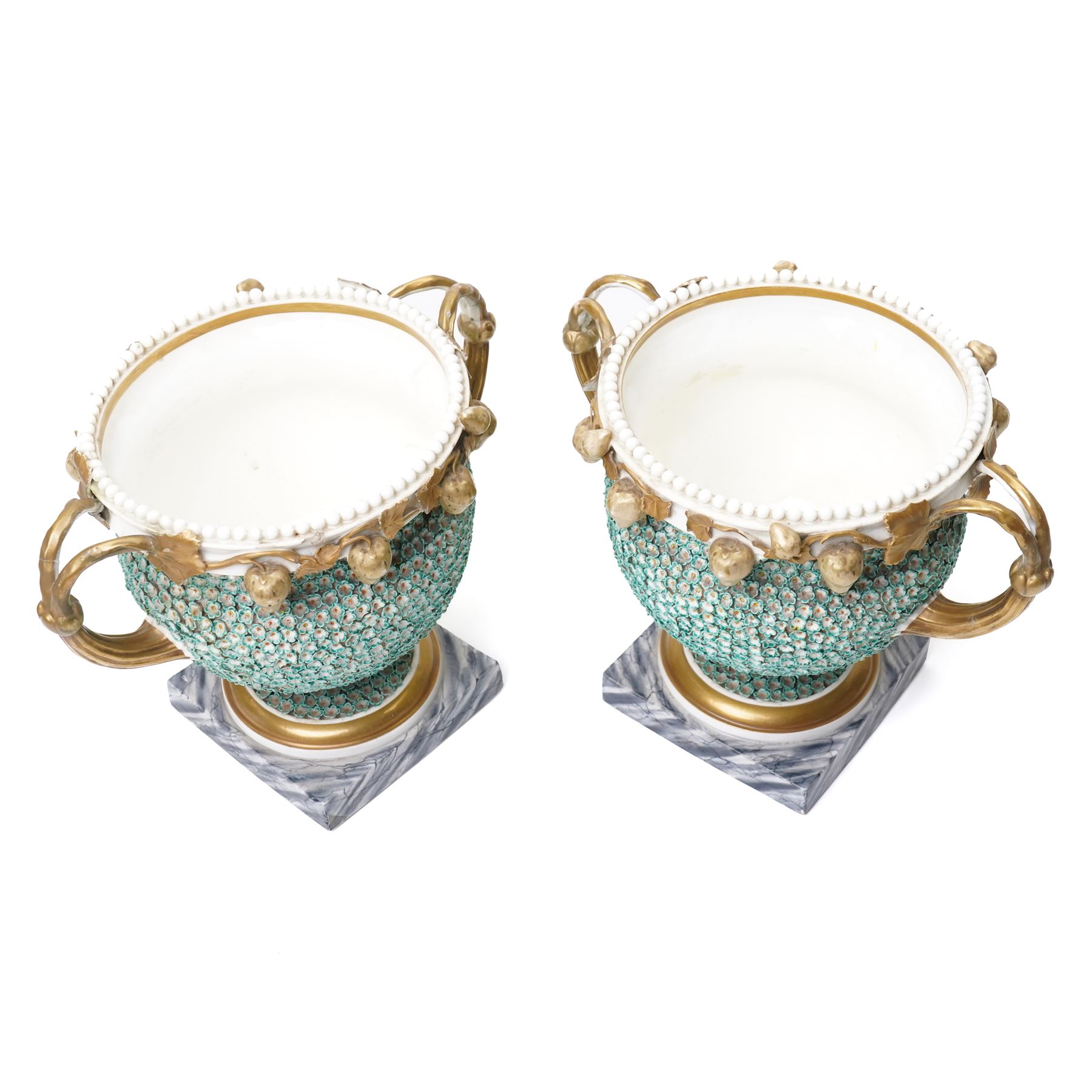 Pair of 19th century Grainger Lee & Co Worcester urns, c1820s-1830s, hand-painted with views of 'Near London Bridge' and 'Brighton Pavilion' upon a ground of encrusted forget-me-not decoration, the beaded rim with twin naturalistically formed handles, leading into vines moulded with strawberries in high relief, the pedestal painted to imitate marble, painted marks to base, H20cm