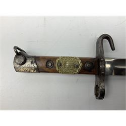 Austrian Model 1895 Carbine NCO's knife bayonet with 24.5cm fullered steel blade and applied embossed brass crested badge to the grip, in steel scabbard L38cm overall