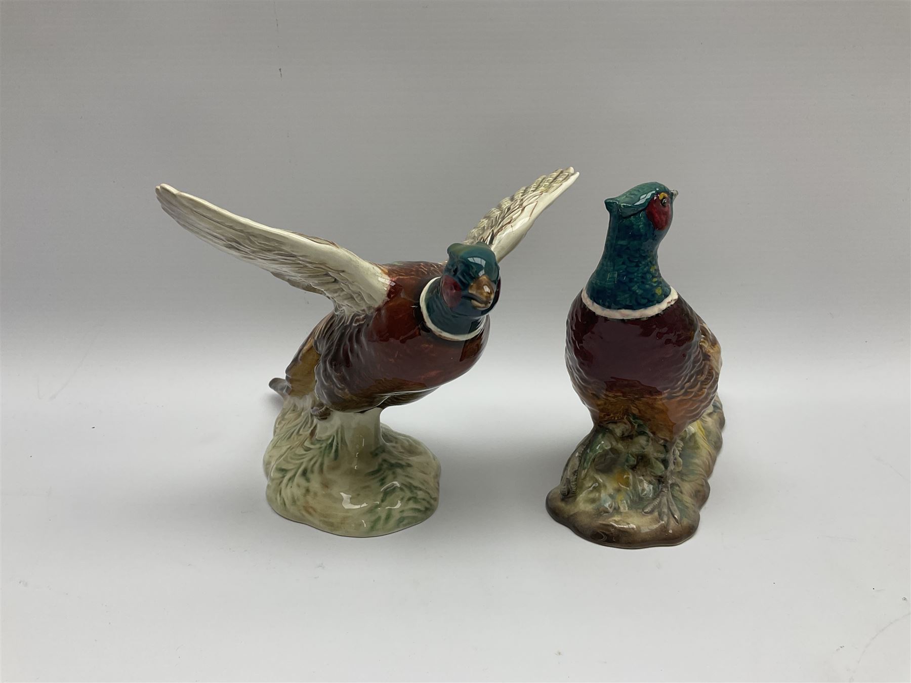 A collection of Beswick figures, comprising ginger cat model no 1898, ginger Persian kitten model no 1886, pheasant in flight model no 849, and pheasant model no 1226b.  