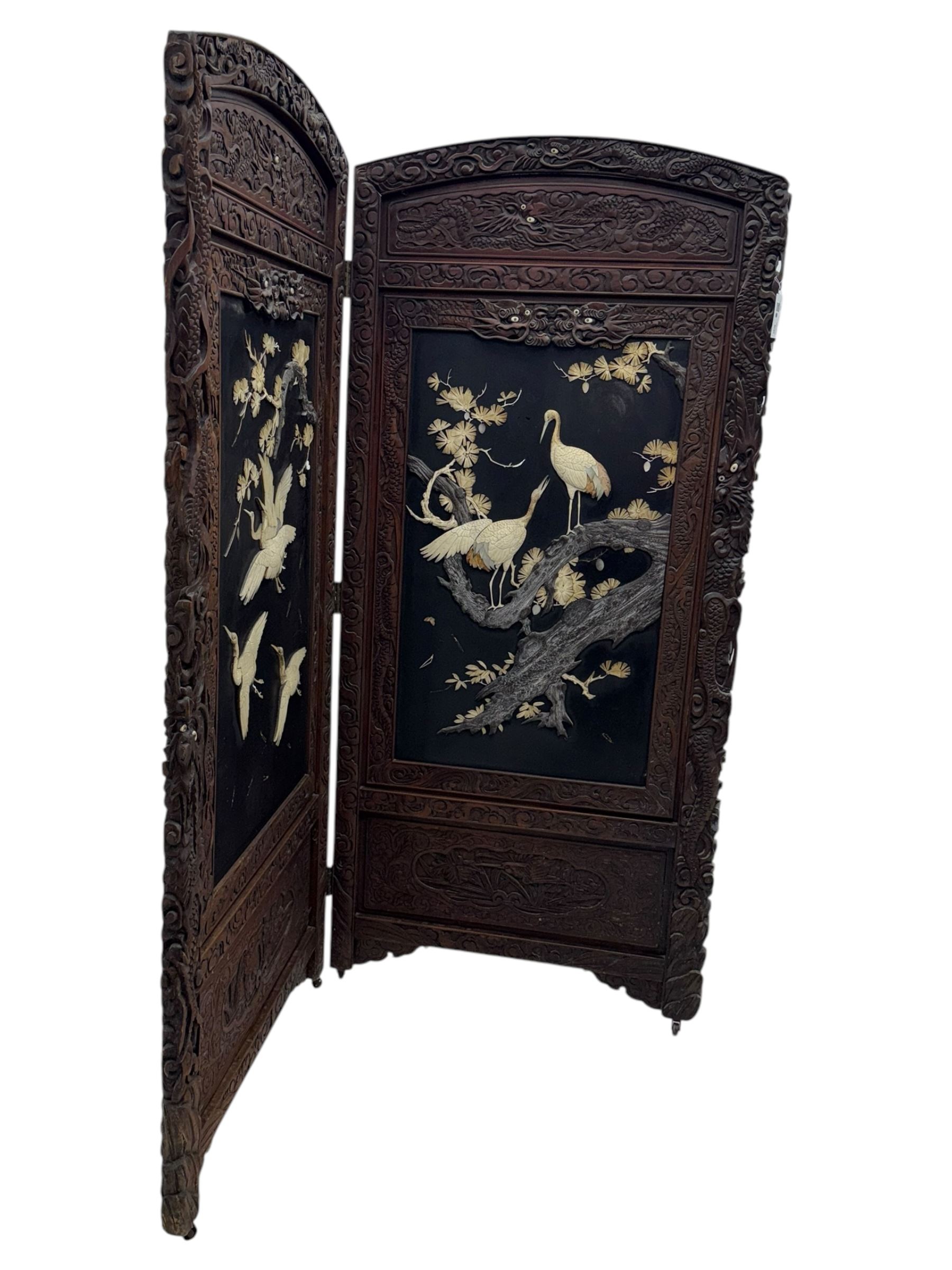 Meiji period (1868–1912), Shibayama lacquer carved hardwood two-fold screen inlaid with mother-of-pearl, bone, and ivory, decorated on one side in high relief and inlaid in a  Shibayama manner with oriental storks flying below flowering branches,  the reverse lacquer panels depicting flowering cherry trees. This item has been registered for sale under section 10 of the APHA Ivory Act.