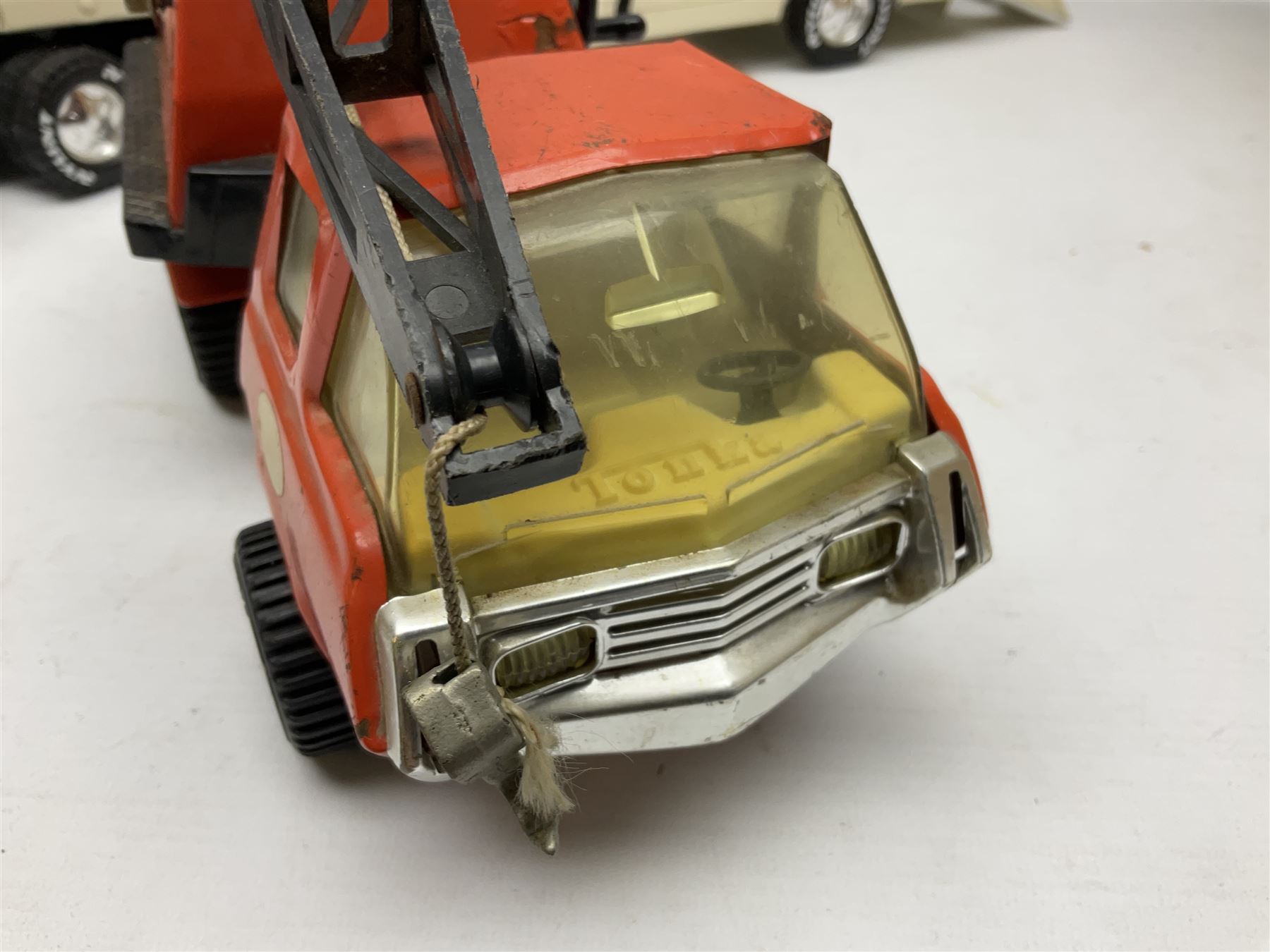 American Nylint large scale tin-plate car transporter L59cm carrying a Testor Toys plastic car; Tonka tin-plate mobile crane; boxed Sarony Cigarettes tin-plate roulette game with rules; and Japanese style tin-plate box, the lid inset with a revolving poker dice game (4)