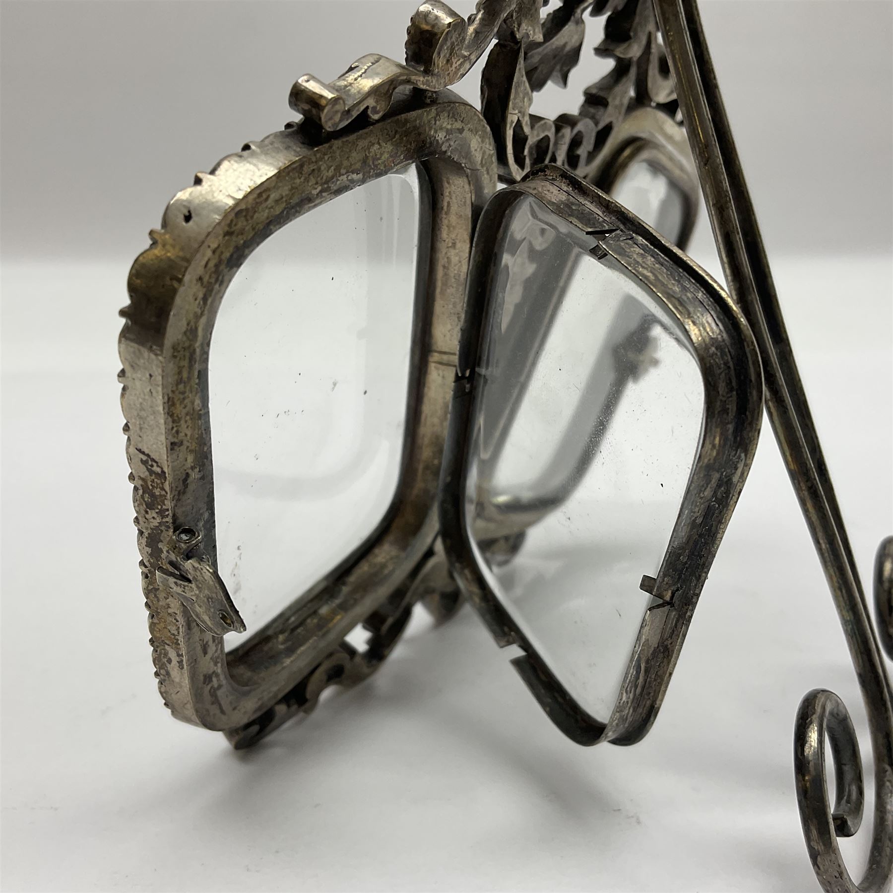 Early 19th century silver plated double photograph frame, each rounded rectangular aperture surrounded by a paste border, with ornate scroll feet and mantling also set with clear paste stones, with easel style support verso, H12cm