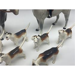 Beswick hunting group, comprising huntswoman on grey horse no 1730, huntsman on brown horse no 1501, fox figure no 1440 and eight fox hounds, all with printed marks beneath (11)
