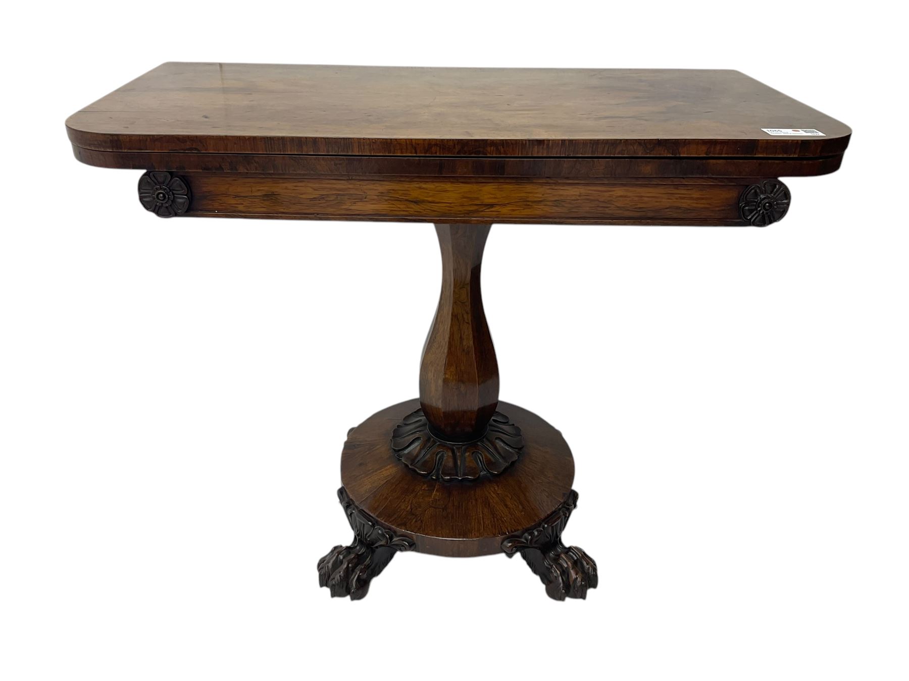 Victorian mahogany tea table, rectangular top with rounded corners, folding and swivelling to reveal interior surface, supported on a faceted baluster-shaped column, raised on a circular platform base with carved acanthus details, ending in four lion paw feet