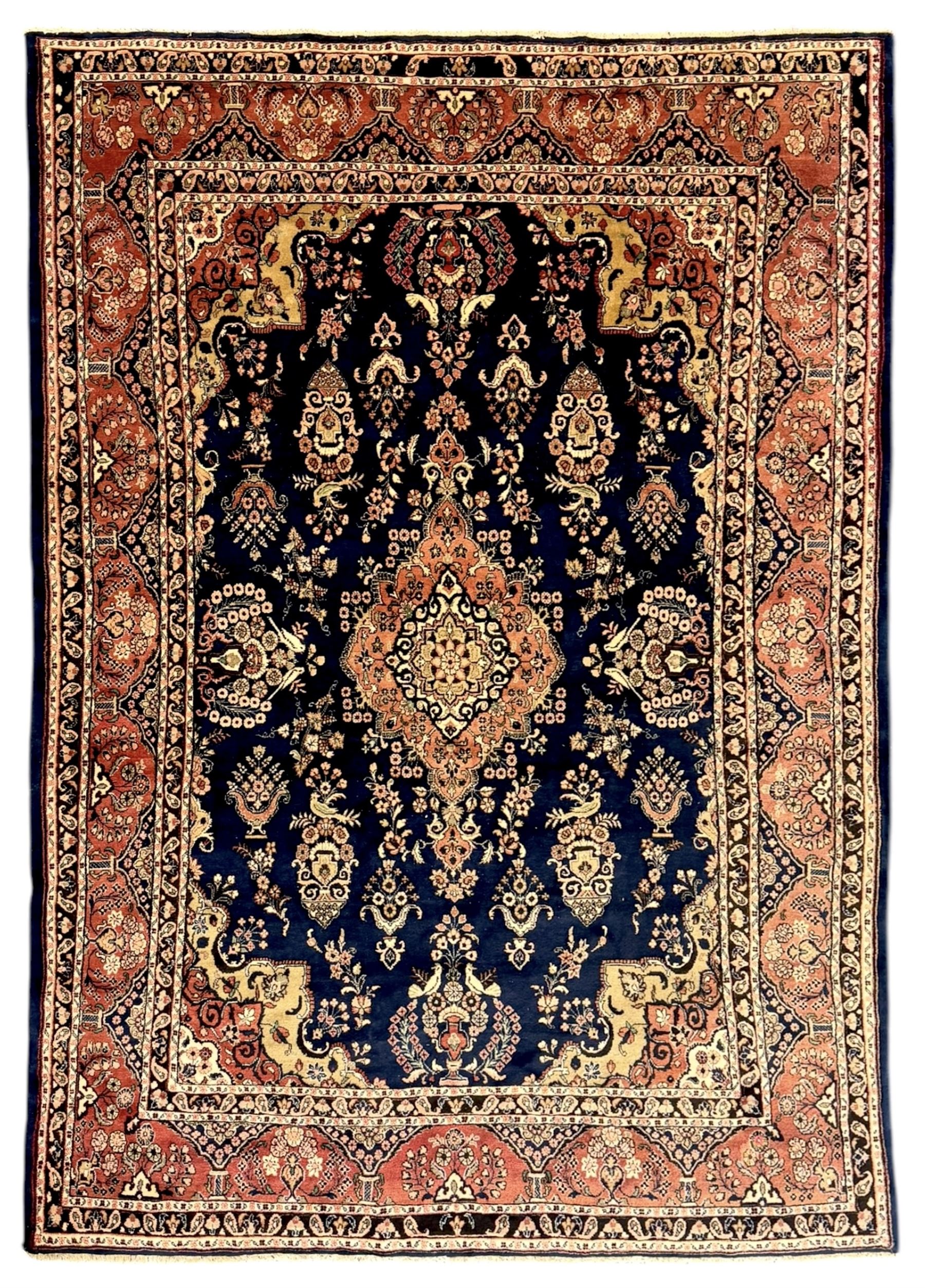 Persian Herati design indigo and red ground carpet, decorated with floral motifs, arched border