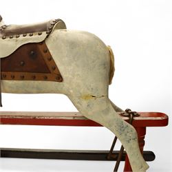 20th century carved and painted rocking horse, with original dappled paint finish, studded leather saddle and reins, on later red and black swing frame