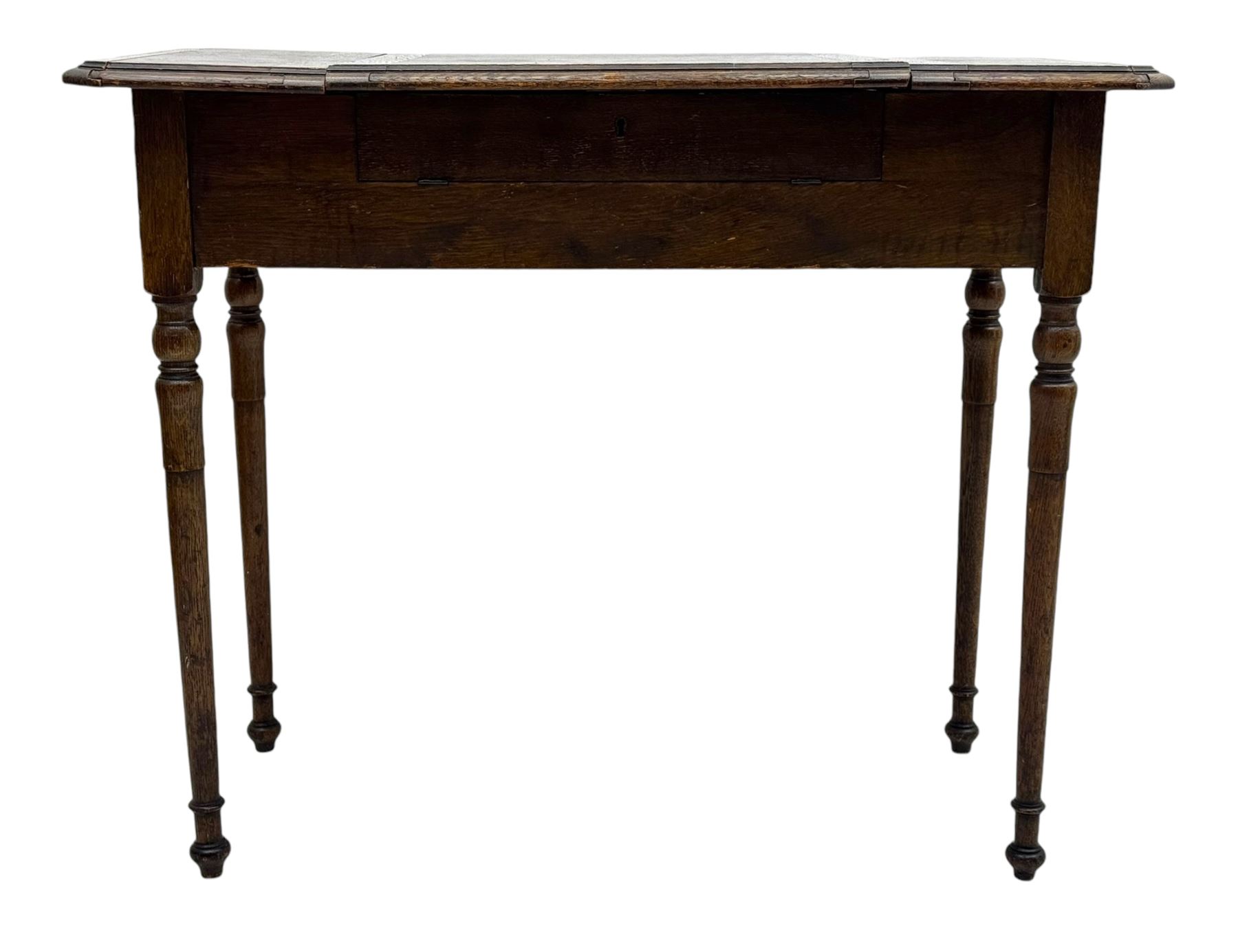 Edwardian oak metamorphic 'Britisher Writing Table', rectangular hinged top revealing correspondence compartments and hinged writing surface with underside storage, flanked by twin hinged compartments with dividers, on turned supports