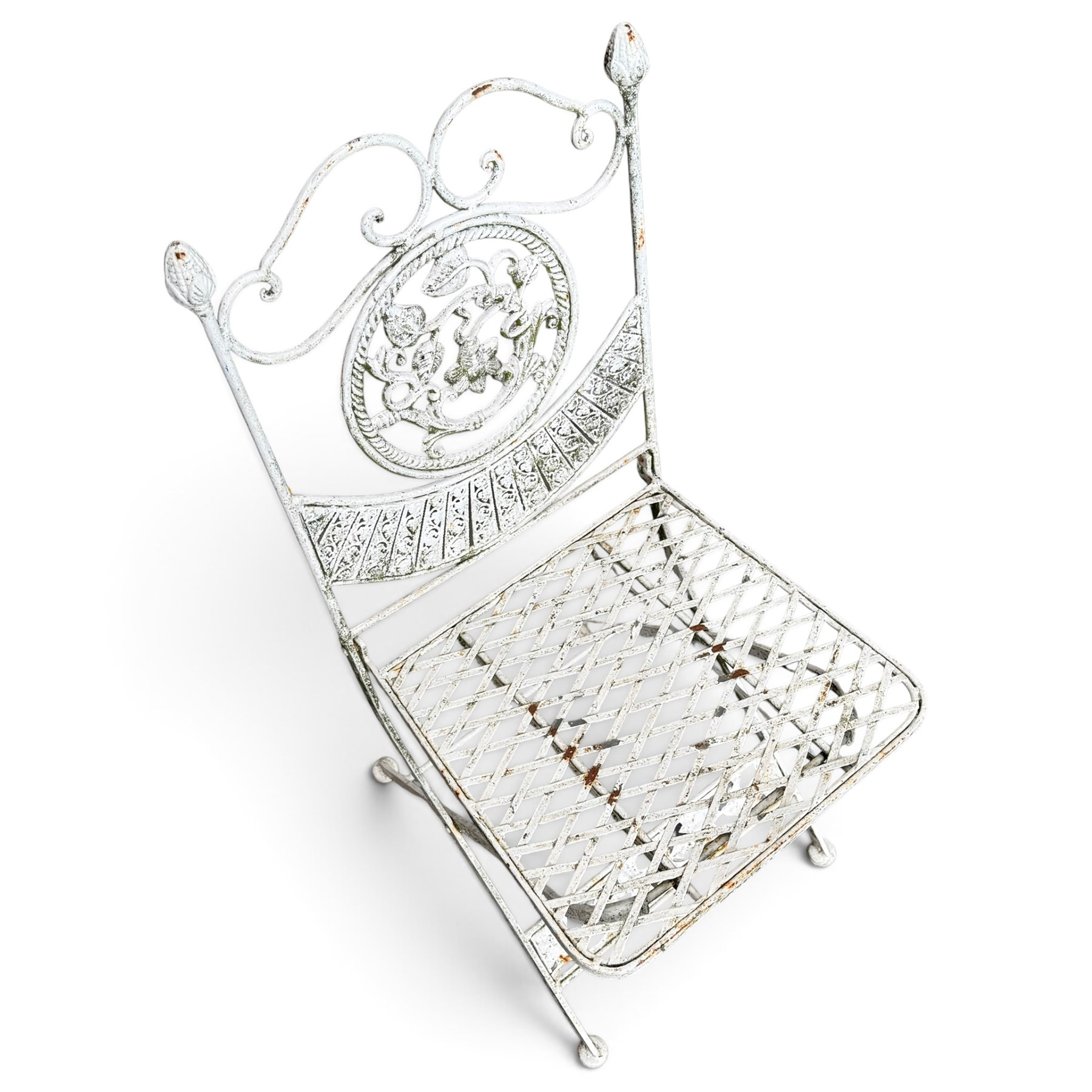 Three-piece French style white-painted wrought iron garden bistro set, comprising a circular folding table with latticework top and apron with scrolling foliate motifs (W70cm H80cm) and matching pair of chairs, with scrolling cresting rail and acorn finials over a scrolled foliate medallion, raised on lattice seat and folding X-frame base (W42cm H93cm)