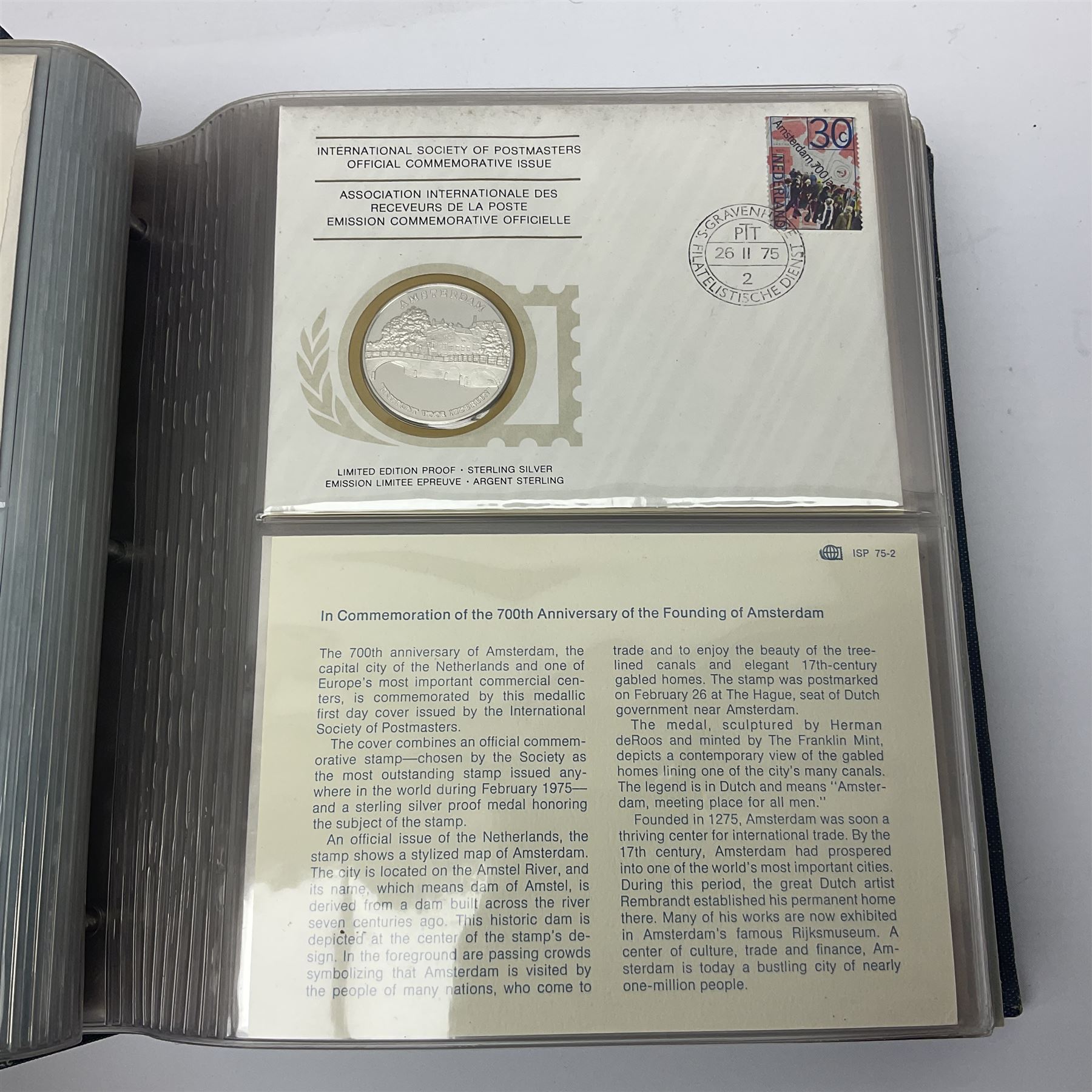 Thirty-one 'International Society of Postmasters Official Commemorative Issues' sterling silver proof medallic covers dating from 1975 to1977, housed in the official folder and a 'Commemorating The Bicentennial Of The United States Of America' sterling silver proof medallic first day cover in blue wallet