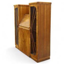Art Deco walnut bureau bookcase, top with moulded and rounded edges and stepped front profile, central shelf, and fall-front bureau section with vertical and horizontal pigeon holes and a small drawer, above two cupboard doors and flanked by two tall glazed display cabinets with single doors and geometric sunburst design astragal glazing bars enclosing three shelves, raised on cavetto shaped plinth base 