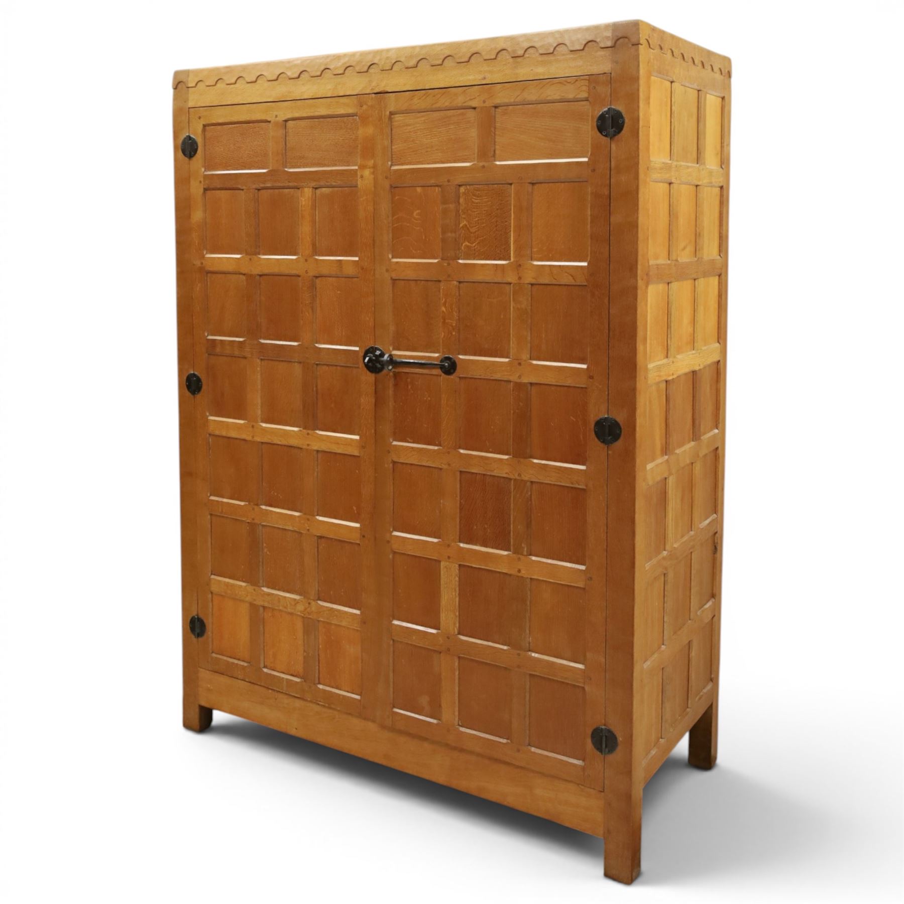 Mouseman - early-to-mid-20th century panelled and adzed double wardrobe, the arcade carved cresting rail over two panelled doors, with wrought metal hinges and latch, deep relief carved mouse signature, the interior fitted with hanging rail, by the workshop of Robert Thompson of Kilburn