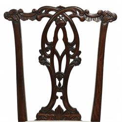 Chippendale revival mahogany dining chairs, set of six including a pair of carvers, the backs with intricately carved pierced splats beneath serpentine cresting rails, on acanthus carved cabriole front supports terminating in claw and ball feet, with cream upholstered drop-in seats