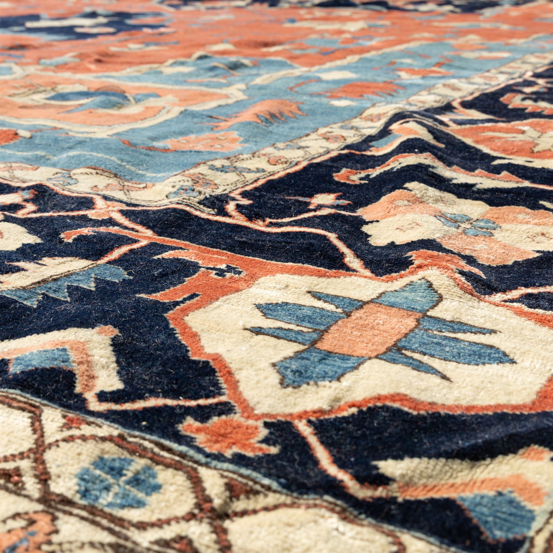 Exceptionally large Northwestern Persian Heriz, hand-knotted carpet, madder red field with a bold stepped medallion in indigo and ivory, and light blue spandrels within a dark indigo border of rosettes and angular vine motifs 




