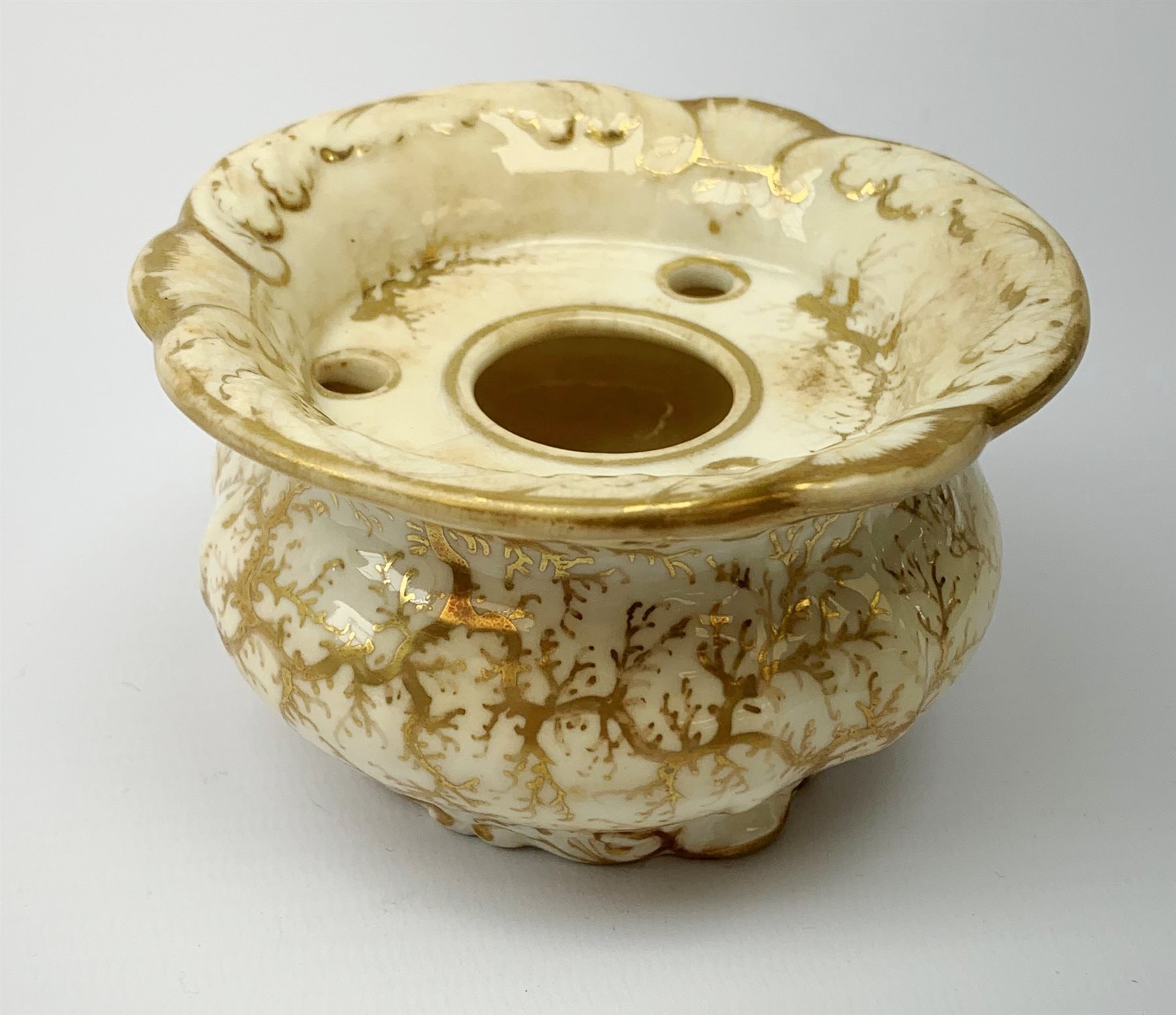 A Rockingham inkwell, with scroll rim, the whole decorated in gilt with a seaweed pattern, with a printed puce mark beneath, D9.5cm. 