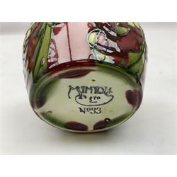 Three Minton Secessionist vases, with tube-lined stylised flower decoration, two upon a red ground and third upon a purple ground, all with printed mark to base 'Minton Ltd, No. 33', H13cm