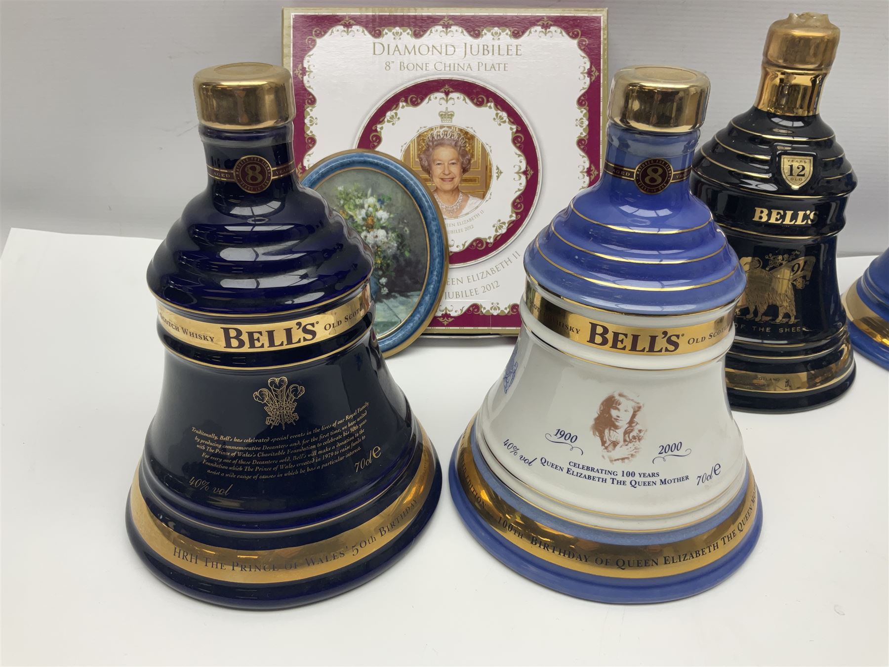 Bells, Scotch whisky, in seven Wade ceramic decanters, to include 50 year reign HM Queen Elizabeth II, Ninetieth Birthday of the Queen mother, 1991 year of the sheep, etc, together with two empty decanters and other items 