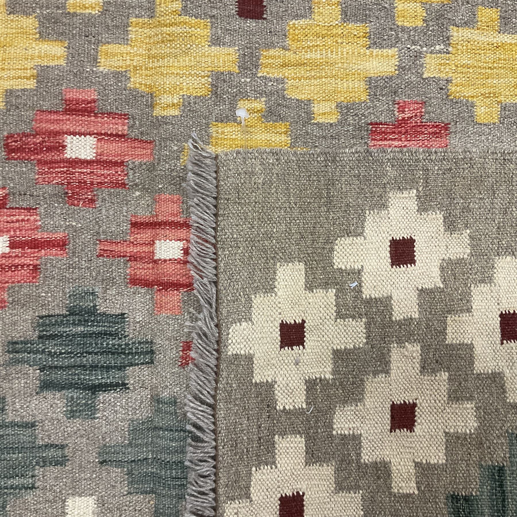 Anatolian Turkish kilim, light grey ground and decorated with multi-coloured geometric star motifs