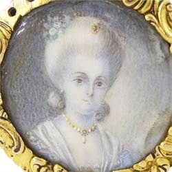 19th century gold portrait ring, set with a circular miniature of a young woman in 18th century dress on ivory, under a glazed panel, within a gold scroll frame and pierced gallery. This lot has been registered for sale under Section 10 of the APHA Ivory Act