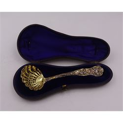 Victorian silver-gilt sugar sifting spoon, with gilded pierced shell shaped bowl, the handle decorated in relief with classical greek figures amongst fruiting vines, hallmarked Henry John Lias & James Wakely, London 1874,  L16cm, contained within tooled leather silk and velvet lined fitted case