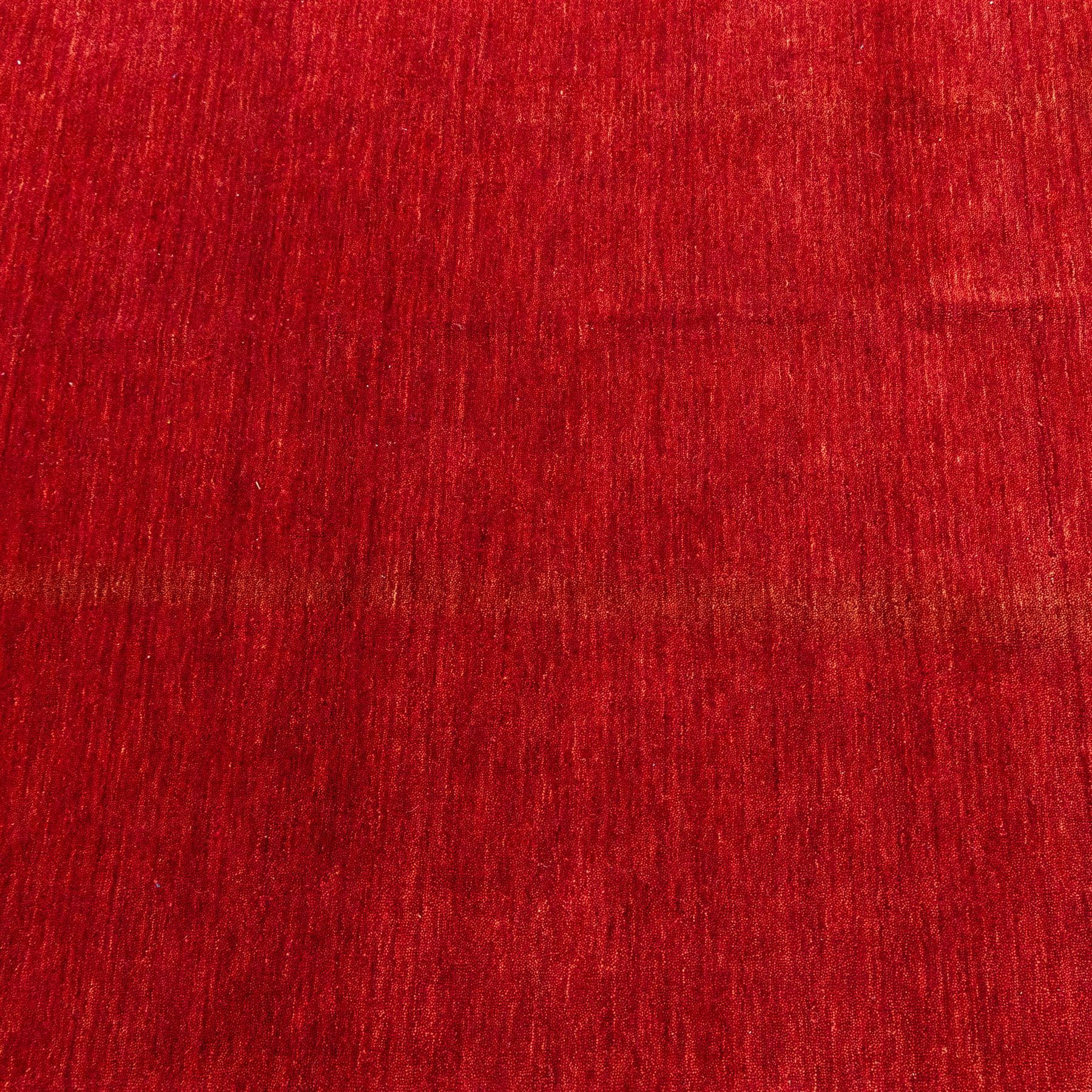 Two contemporary Moroccan Berber hand-woven rugs, deep madder red field of plain design, 199x153cm, other with deep madder red field with a simple lattice of ivory lines forming panels with some tonal variation, 190x146cm 