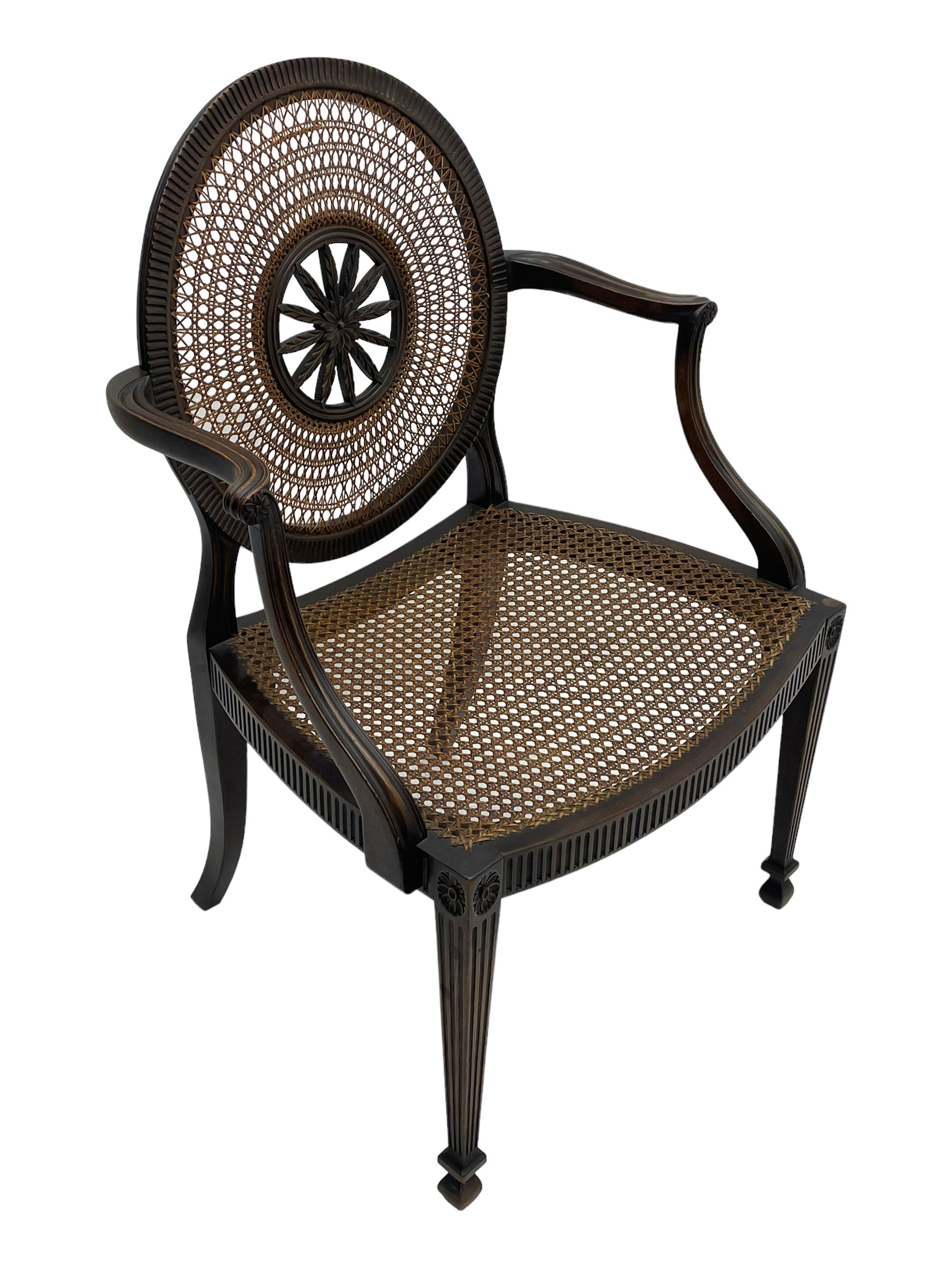 Mid-to late 20th century walnut Hepplewhite design elbow chair, circular cane back with pierced and carved central rosette, fluted frame with scrolling arms, cane seat raised on fluted rail and square tapering supports with spade feet