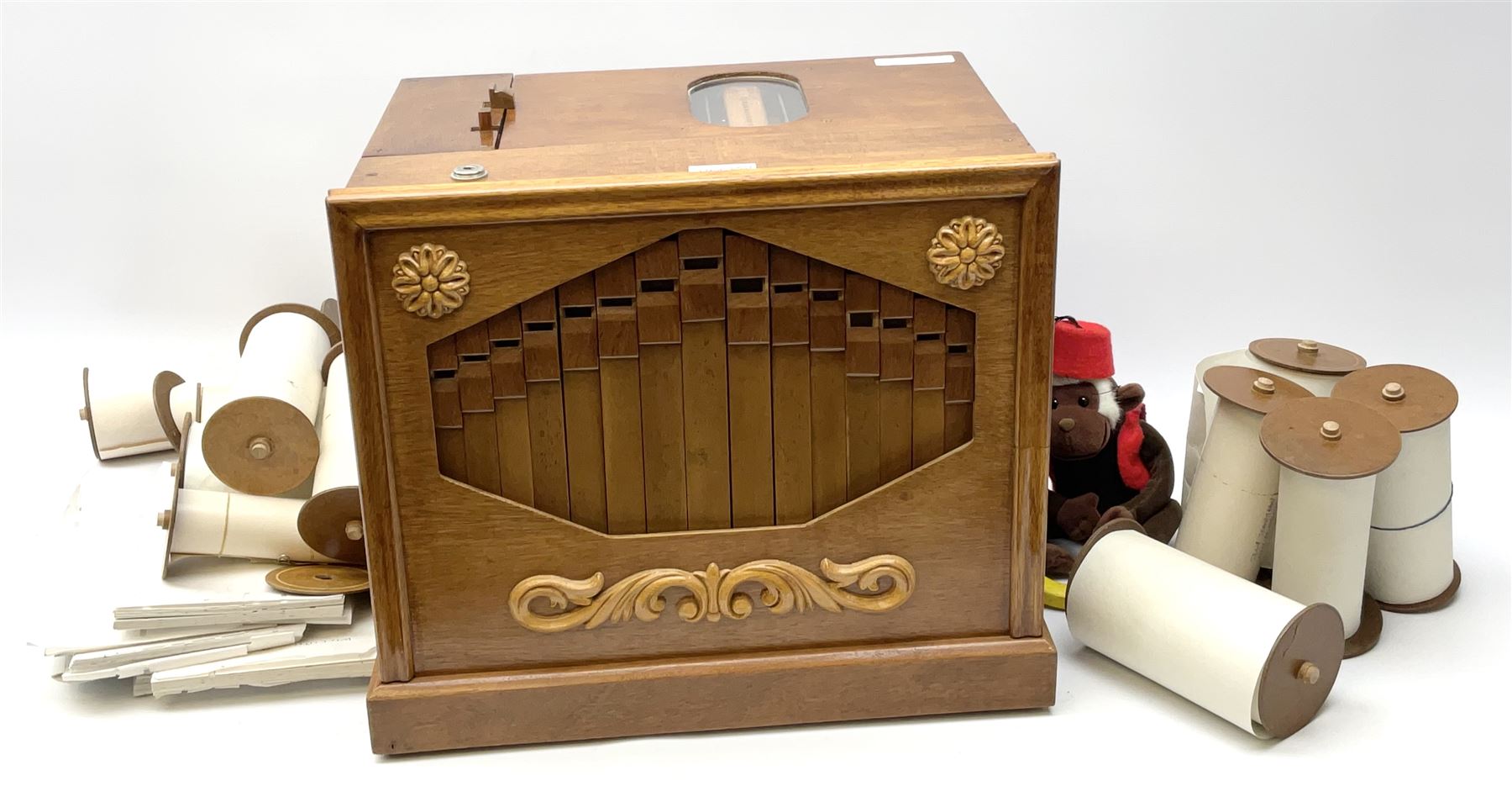 Small scratch built wooden John Smith style twenty-note busker organ with thirteen paper music rolls, other paper music and soft toy monkey