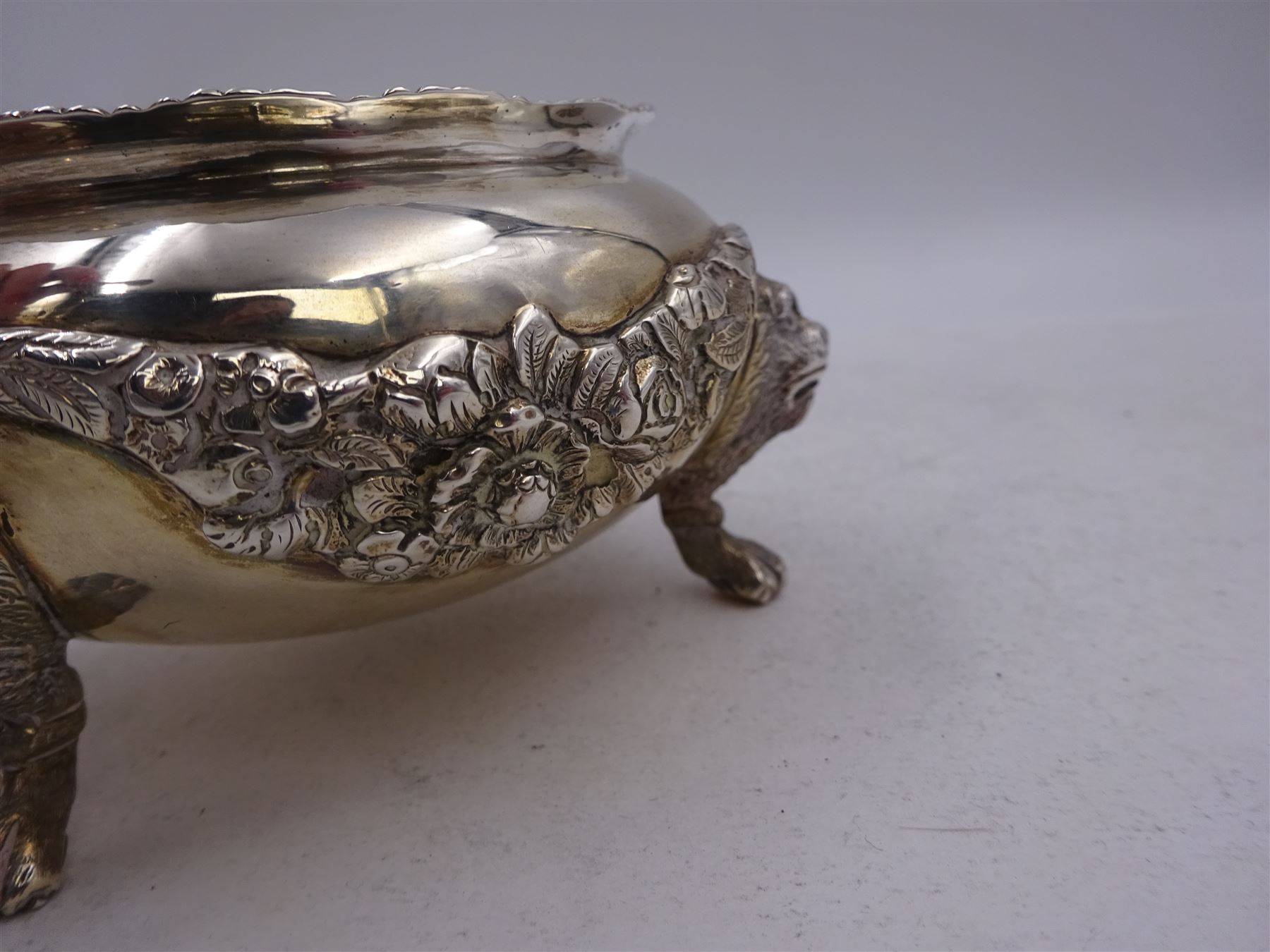 Early 20th century silver open sucrier, of circular form, with fluted gadrooned rim and decorated in relief with floral swags, united by three lion mask mounts and upon three paw feet, hallmarked Z Barraclough & Sons, London 1912, H6cm, D11cm, with similar spoon with lion mask finial, hallmarked London 1912, maker's mark indistinct