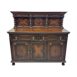 Jacobean-style oak dresser base with two frieze drawers above three cupboards with panelled and moulded decoration, fitted with drop handles, supported on bun feet, circa 1900