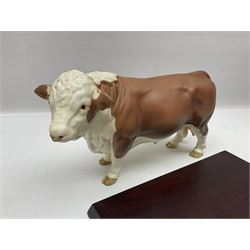 Beswick matte Hereford Bull, with stamped mark beneath, on wooden plinth, together with a limited edition Bradford Exchange John Wayne model, tallest H36cm