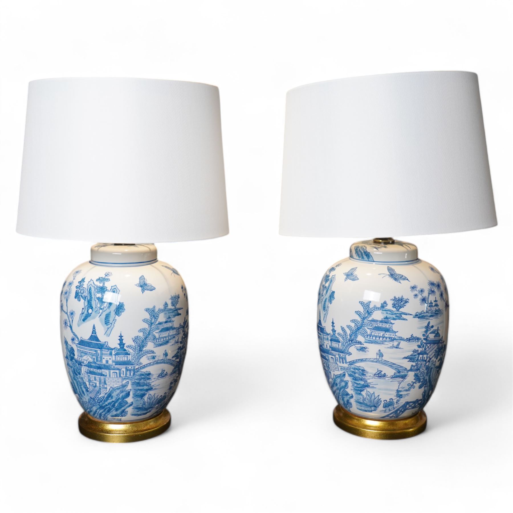Pair of lamps of baluster form, decorated with a Japanese landscape on a white ground raised upon a gilt footed base, H60cm including shades 
