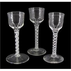 Three 18th century drinking glasses, the ogee bowls upon double series opaque twist stems and conical feet, each approximately H14.5cm